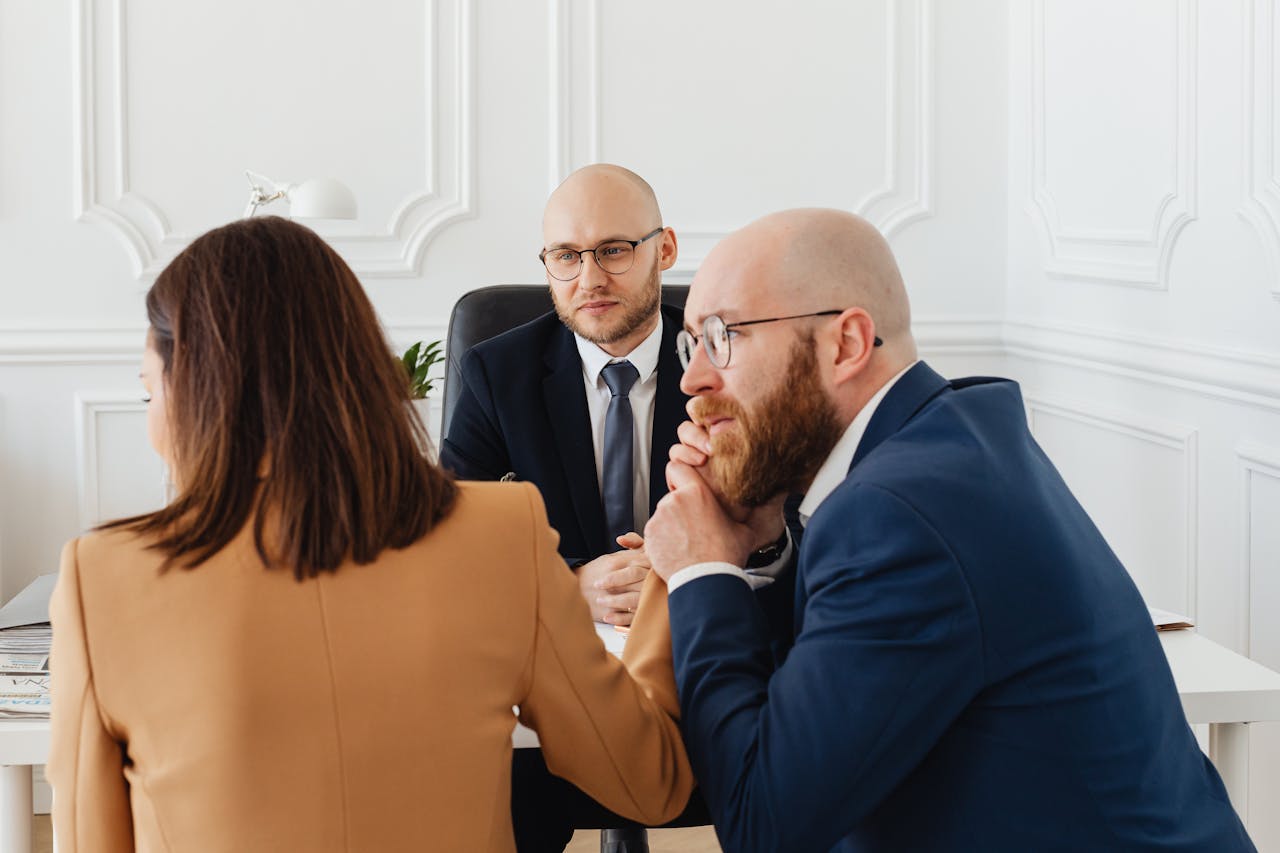 Lawyers consulting with clients in a modern office setting, discussing legal matters.